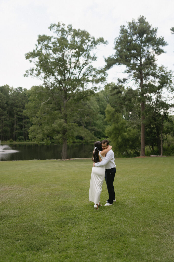 bride and groom taking photos in a green field during their wedding rehearsal dinner