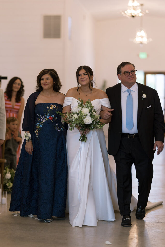 bride walking down the aisle with her parents