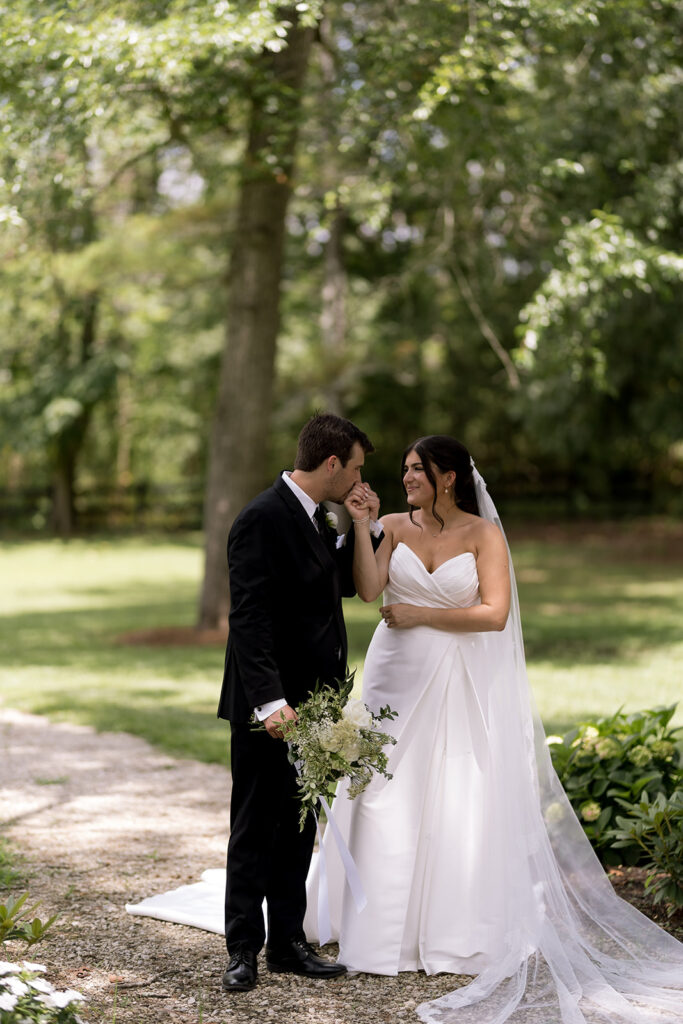 bride and groom in a green field taking photos at Heron Hill Venue